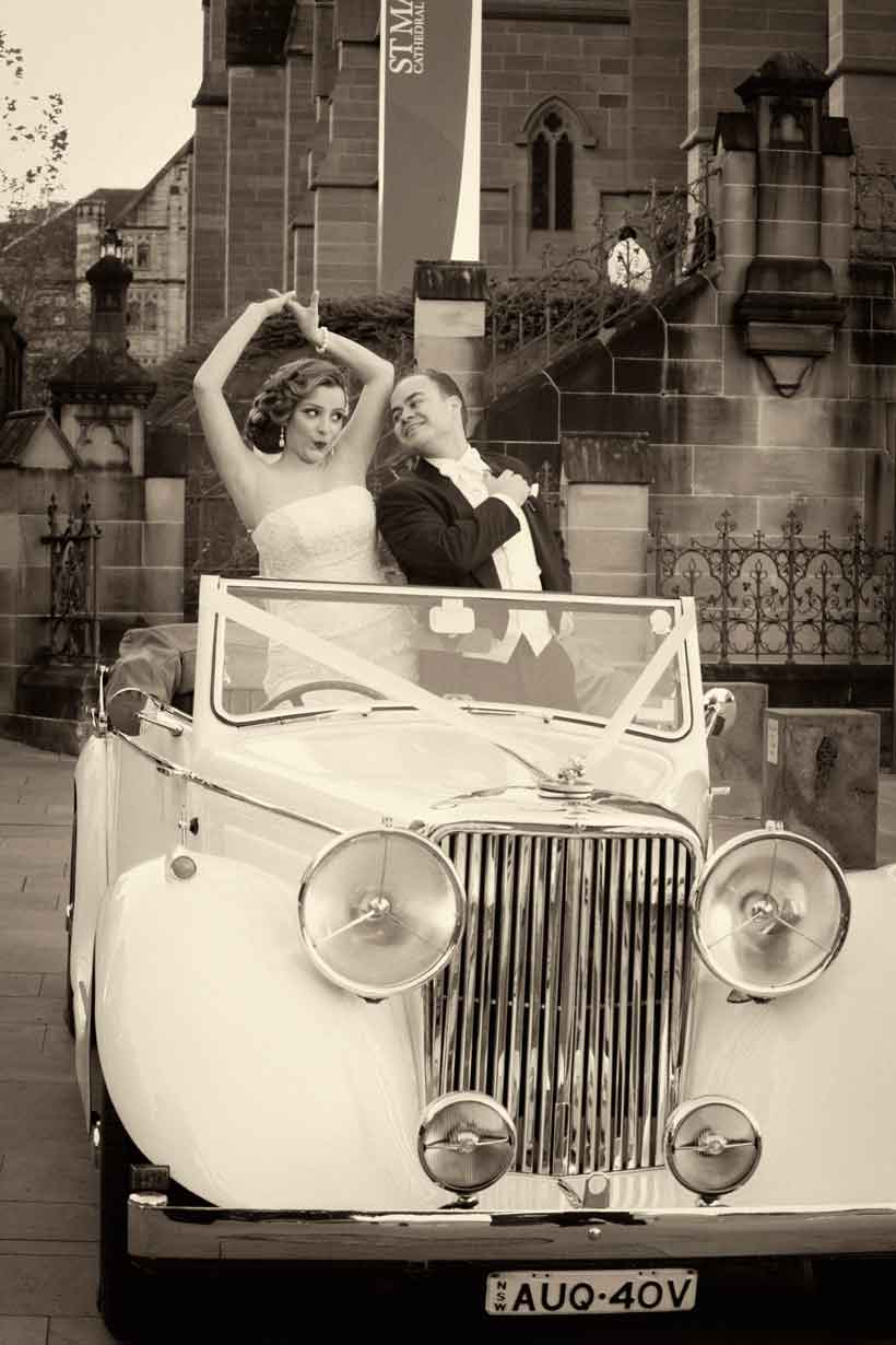 Bride and groom with wedding car