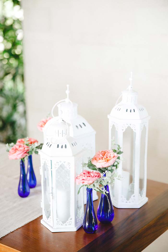 Registration table adorned with lanterns and flowers in blue jar