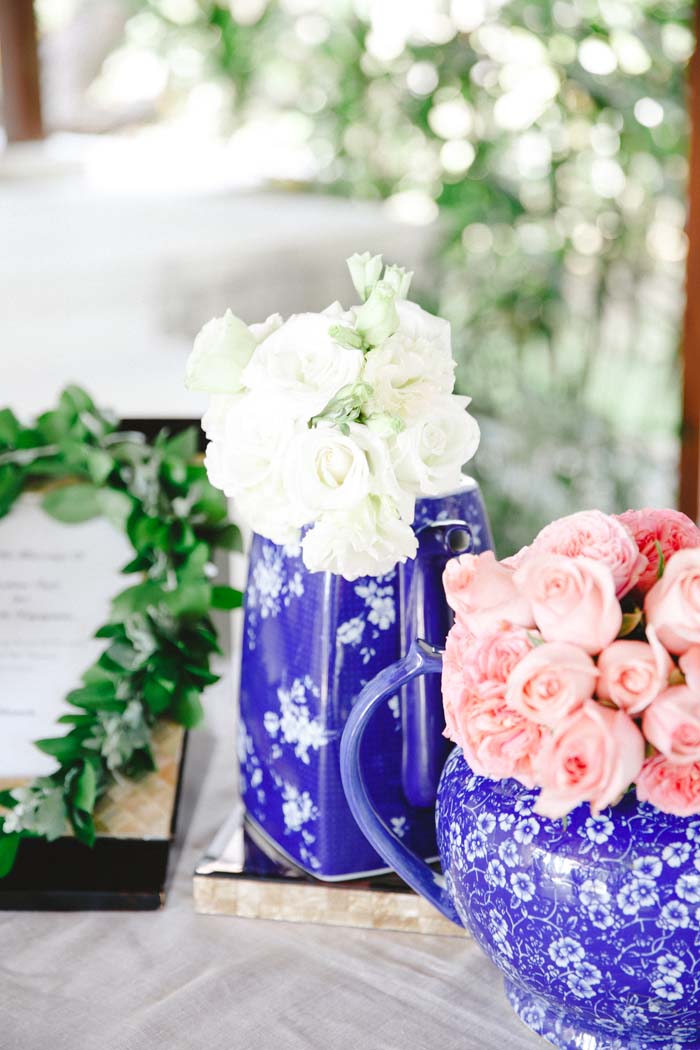 Registration table adorned with white and pink flowers in blue jar