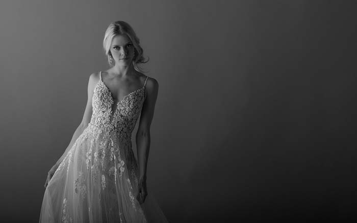 bride looking at camera wearing wedding dress with detailed bodice
